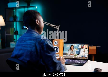 Black woman making video call with group of colleagues on a digital laptop. Attending conference meetings and webinars via portable computer as an African American female freelancer. Stock Photo