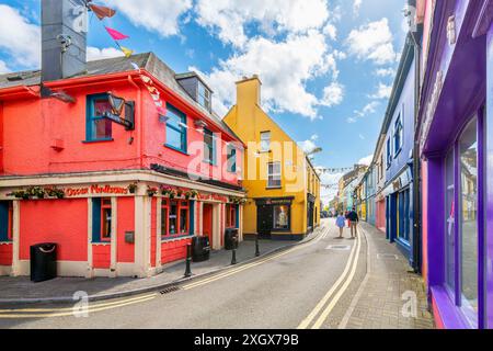 Main Street, the central road through historic old town district of the seaside village of Kinsale, Ireland, known for it's brightly painted shops. Stock Photo