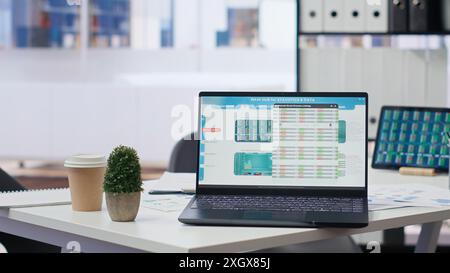 Financial analyst workplace featuring laptop and tablet displaying stock exchange data and statistics. Close up shot of devices on desk next to paperwork with forex trading economic analytics figures Stock Photo