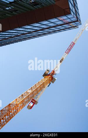 Upward View of Yellow Construction Crane and Building Stock Photo