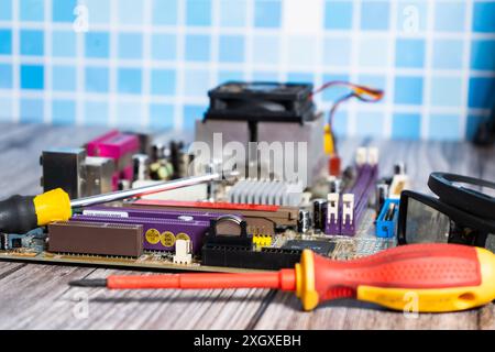 A motherboard and a screwdriver on a table. Stock Photo