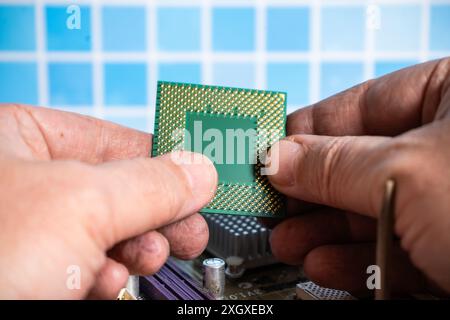 A Computer technician checking the contacts of a microprocessor Stock Photo