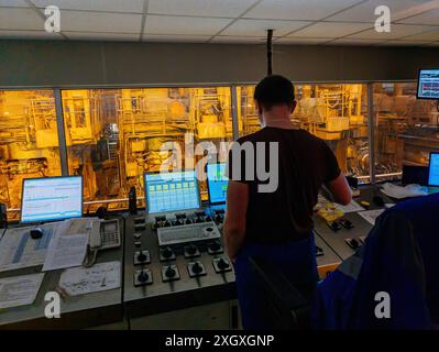 Control room. Operator works with industrial control panel inside metalworking factory. Stock Photo