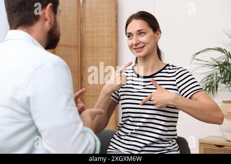 Man and woman using sign language for communication at home Stock Photo