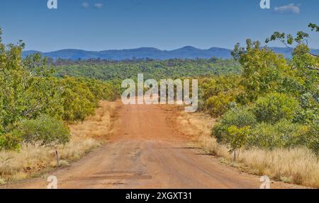 End of the bitumen on a remote outback dirt 4WD road between Gregory Downs and Lawn Hill with distant ranges and forest, Queensland, Australia Stock Photo