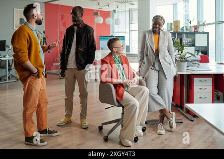 Group of diverse professionals collaborating on business tasks in modern office, emphasizing teamwork and inclusivity Stock Photo