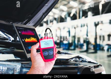 OBD2 or OBD scanner tool and laptop for engine system analysis to fixing car engine system in the auto repair shop , Car maintenance service concept Stock Photo