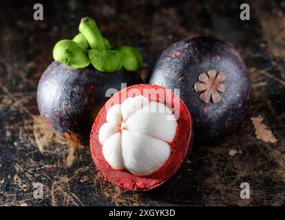 Closeup view of fresh mangosteen on wooden table. Amazing natural juicy tropical fruit with sweet white flesh. Healthy eco food. Stock Photo