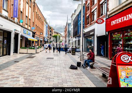 Belfast , County Antrim Northern Ireland July 05 2024 - Busker playing a guitar performing in Ann Street Belfast City Centre Stock Photo