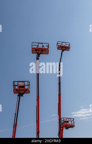 Arrows of construction lifts on a blue sky background. Stock Photo
