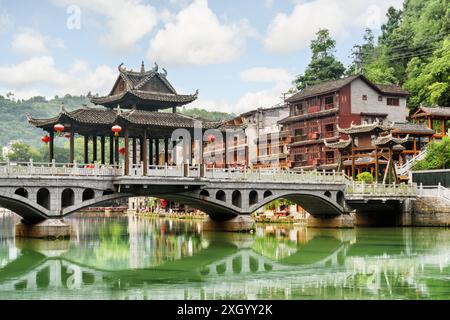 View of amazing bridge reflected in water of the Tuojiang River (Tuo Jiang River) in Phoenix Ancient Town (Fenghuang County), China. Stock Photo