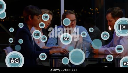 Image of 6g text and symbols in circles over diverse coworkers sharing ideas in cafes. Digital composite, technology, business, planning, discussion, Stock Photo
