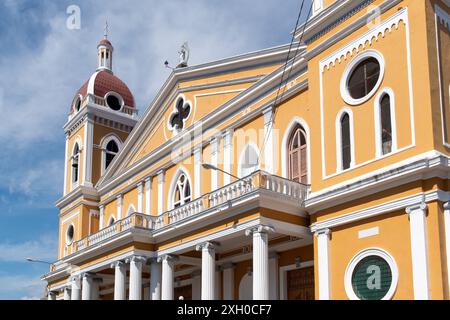 Granada, Nicaragua - March 24, 2019: Historic yellow church with red dome basks in sunlight. Stock Photo