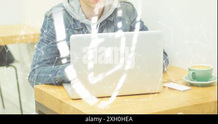 Image of padlock in shield and connected dots forming shapes over caucasian man using laptop. Digital composite, multiple exposure, protection, securi Stock Photo