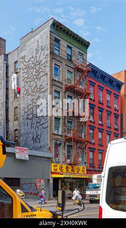 NYC Chinatown: A typical brick-and-terra cotta walk-up apartment building above a store with Chinese sign, on a quiet weekday morning. Stock Photo