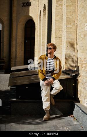 Young red haired man posing in front of city building. Stock Photo