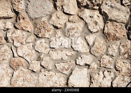 The stone wall is lined with natural stone and cemented. Natural building material. Medieval background Stock Photo