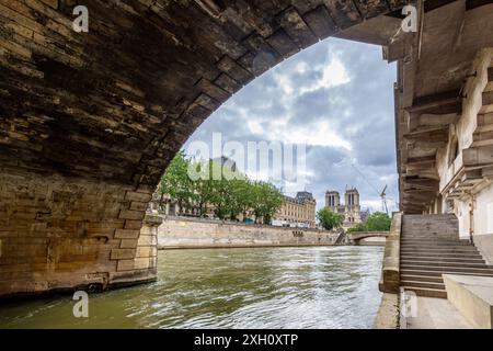 View of the Seine river in Paris,France, from under an arch of the Saint-Michel Bridge, with the Notre-Dame Cathedral in the background Stock Photo