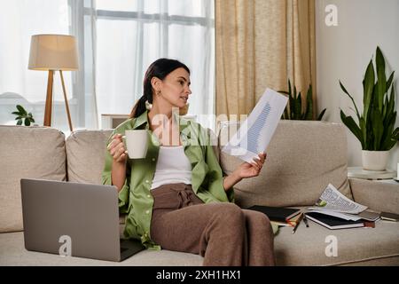 Casual woman enjoying coffee while sitting on a couch. Stock Photo