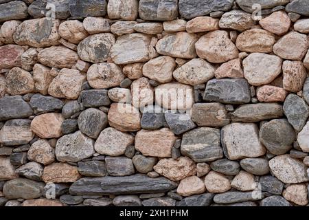 Stone wall texture background with different sized gray and beige stones Stock Photo