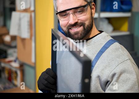 Bearded man is holding frame with mosquito net in his hands Stock Photo