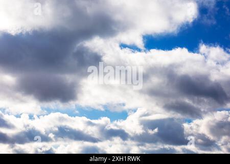 white cumulus clouds on a blue sky. beautiful nature background in afternoon light Stock Photo