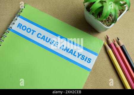 Concept of Root Cause Analysis write on book isolated on Wooden Table. Stock Photo