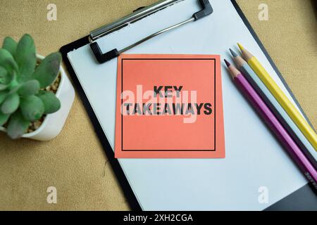 Concept of Key Takeaways write on sticky notes isolated on Wooden Table. Stock Photo