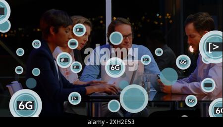 Image of 6g text and symbols in circles over diverse coworkers sharing ideas in cafes. Digital composite, technology, business, planning, discussion, Stock Photo