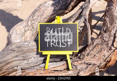 Build trust symbol. Concept words Build trust on beautiful black yellow blackboard. Beautiful tree background. Business and build trust concept, copy Stock Photo