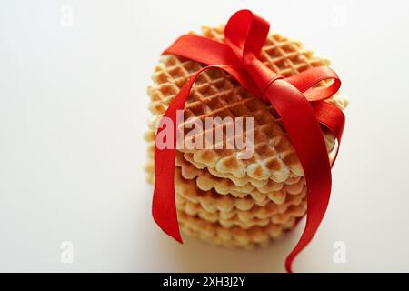 Round waffle cookies wrapped with red ribbon on a white background Stock Photo
