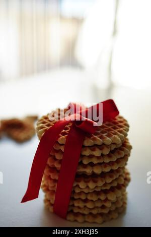 Round waffle cookies wrapped with red ribbon on a white background Stock Photo