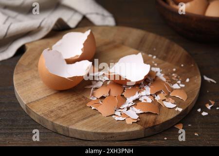 Pieces of broken eggshells on wooden table, closeup Stock Photo