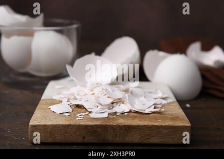 Pieces of broken eggshells on wooden table, closeup Stock Photo
