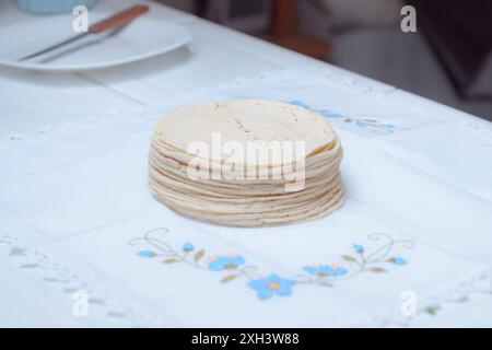 A pile of homemade Mexican tortillas on a table in a kitchen. Stock Photo