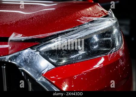 Close-up of a red car headlight with vinyl wrap.  Stock Photo