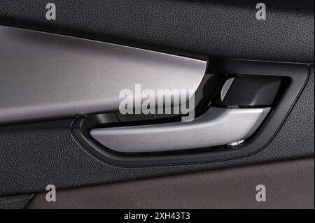 Car door lock handle in leather inside close up view Stock Photo