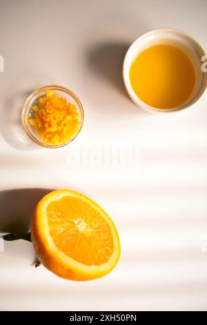 Freshly squeezed orange juice with an orange that has been cut in half Stock Photo