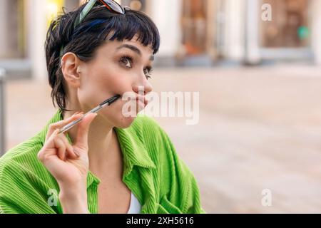 portrait of confused young woman student writing in a notebook, making a plan, learning, studying at the side cafe in city. Concept Lifestyle photo Stock Photo