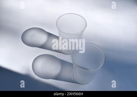 The sun's rays passing through the transparent glasses projected their shadow onto the surface of the table. Stock Photo