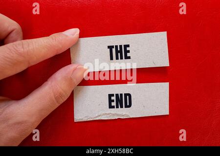 The end message written on paper pieces with red background. Conceptual the end symbol. Copy space. Stock Photo