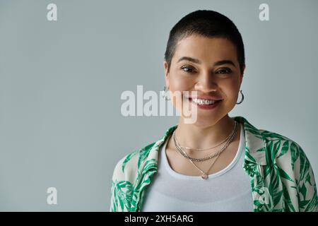 A young woman with short hair is happily smiling, exuding joy and contentment in her casual attire Stock Photo