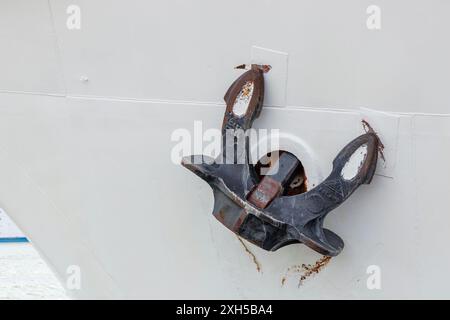View of a rusted ship's anchor on the anchor hole of a white ship on the Baltic Sea. Close-up Stock Photo
