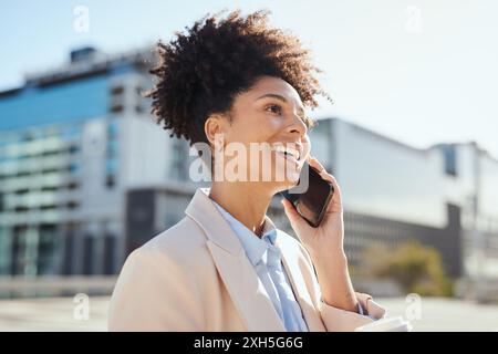 Confident Businesswoman Talking on Smartphone in Urban Setting Under Bright Sunlight Stock Photo