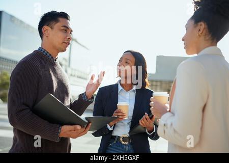 Diverse Entrepreneurs Discussing Business Strategy in Urban Setting With Coffee Stock Photo