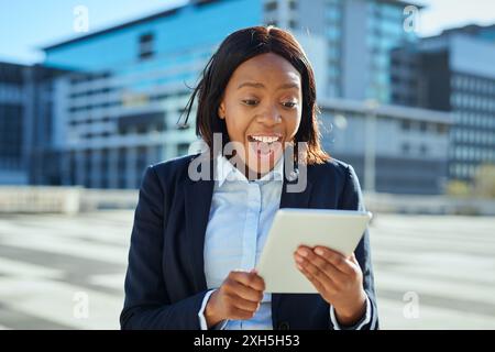 Excited Young Female Entrepreneur Using Tablet in Urban Environment Stock Photo