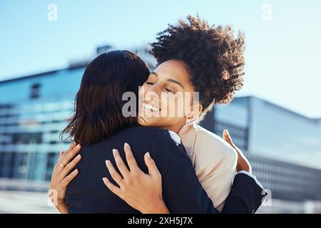 Diverse Businesswomen Hugging Outdoors at Urban Setting, Celebrating Success Stock Photo