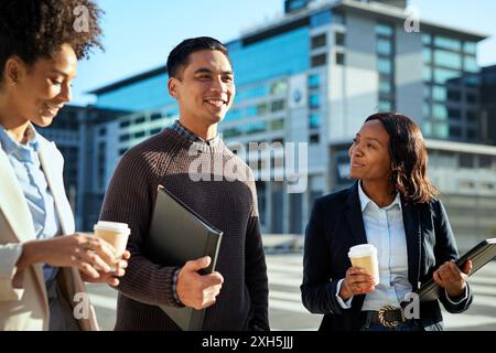 Diverse Group of Young Business Professionals Walking and Talking in Urban Setting Stock Photo