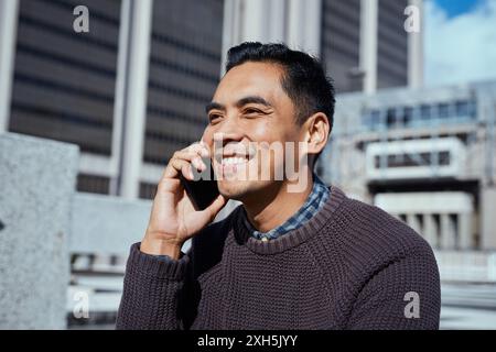 Smiling Man on Phone Call in Urban Setting, Casual Business Attire Stock Photo