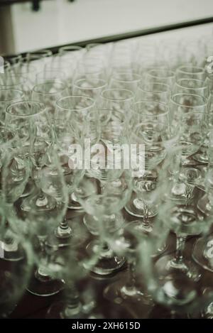 Rows of empty wine glasses arranged on a table. Stock Photo